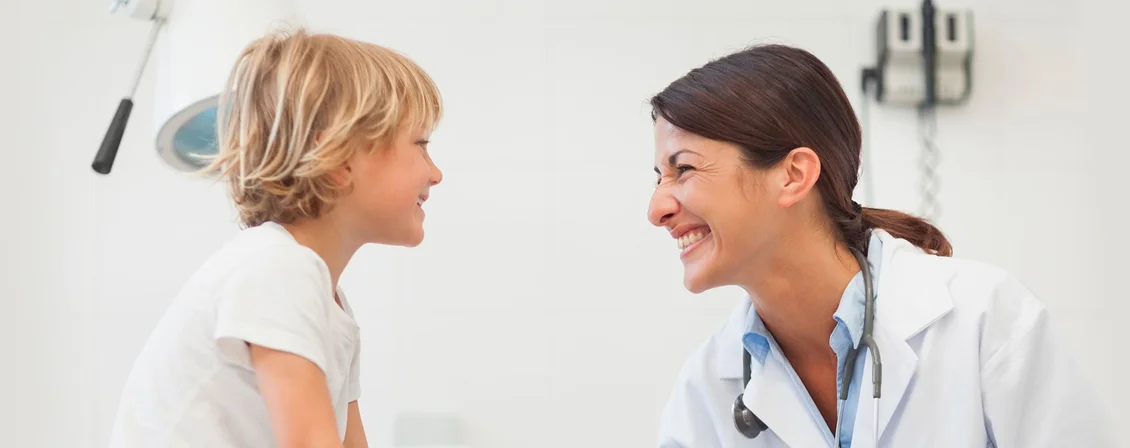 A clinician shares a reassuring smile with a young patient